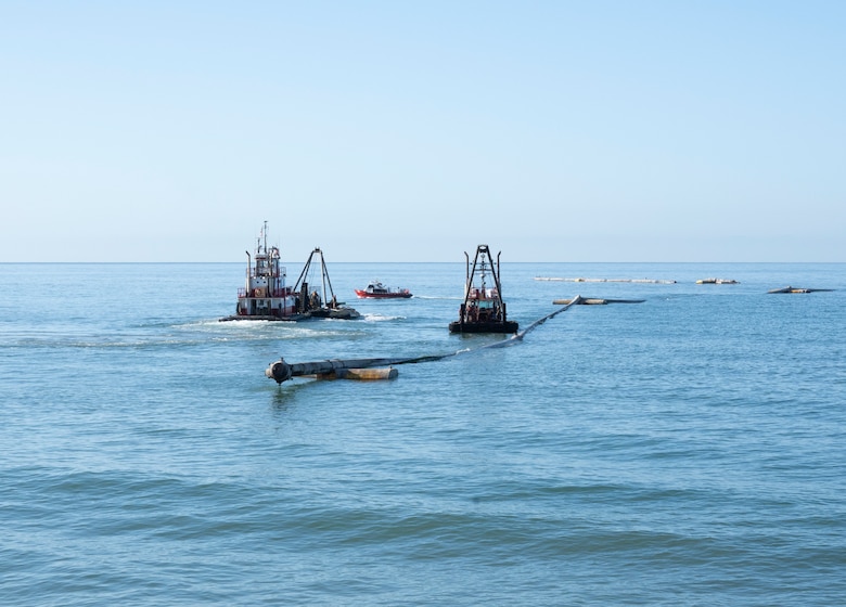 Contractors transport a pressurized dredging pipeline toward the shore Oct. 31 in San Clemente, California.