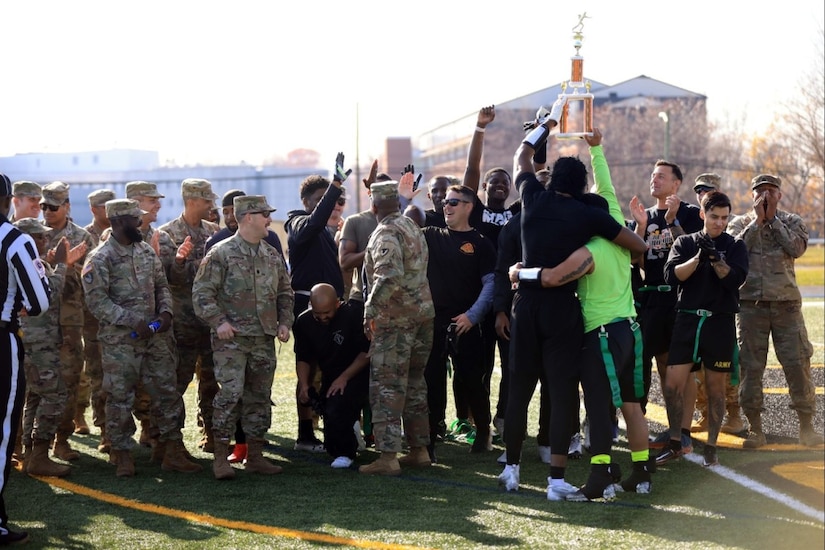 A team holds a trophy after winning a football game.