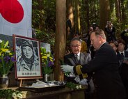 Capt. Michael Fontaine, Commander, Fleet Activities Sasebo, pays homage to the fallen by pouring sake on the downed “Zero” fighter pilot commemorative site during a memorial ceremony held in Isahaya, Japan Nov. 21, 2024.