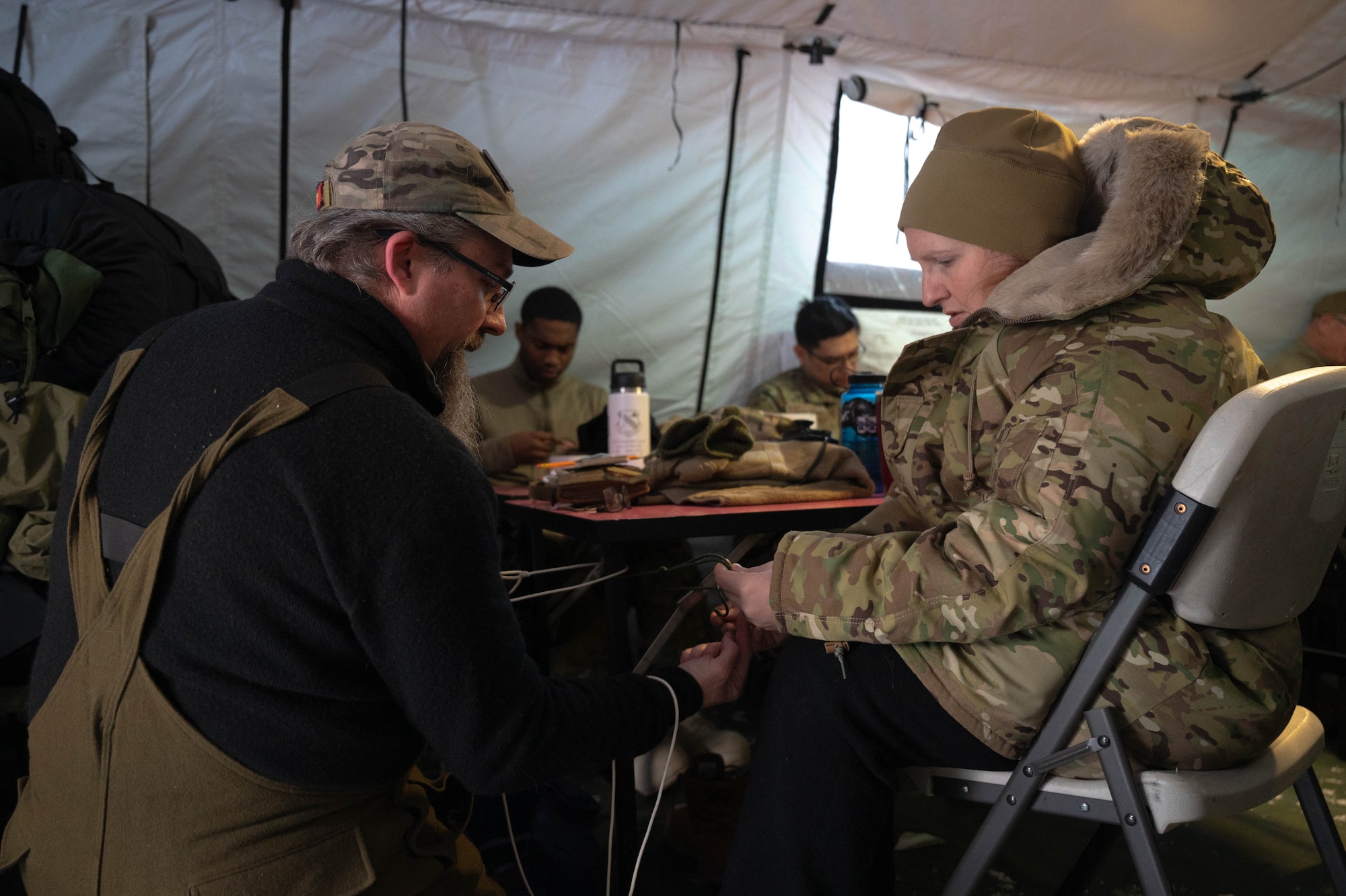 Mr. Jason Mihal, 354th Wing Staff Agency unit training manager, teaches Master Sgt. Kacey Goben, 354th WSA first sergeant, how to tie knots during Arctic Resiliency Training at Eielson Air Force Base, Alaska, Nov. 18, 2024.