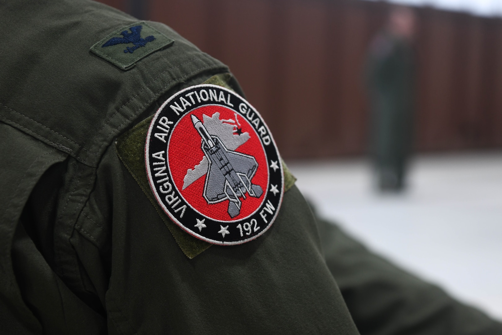 View of Virginia Air National Guard patch on colonel's flight suit shoulder.