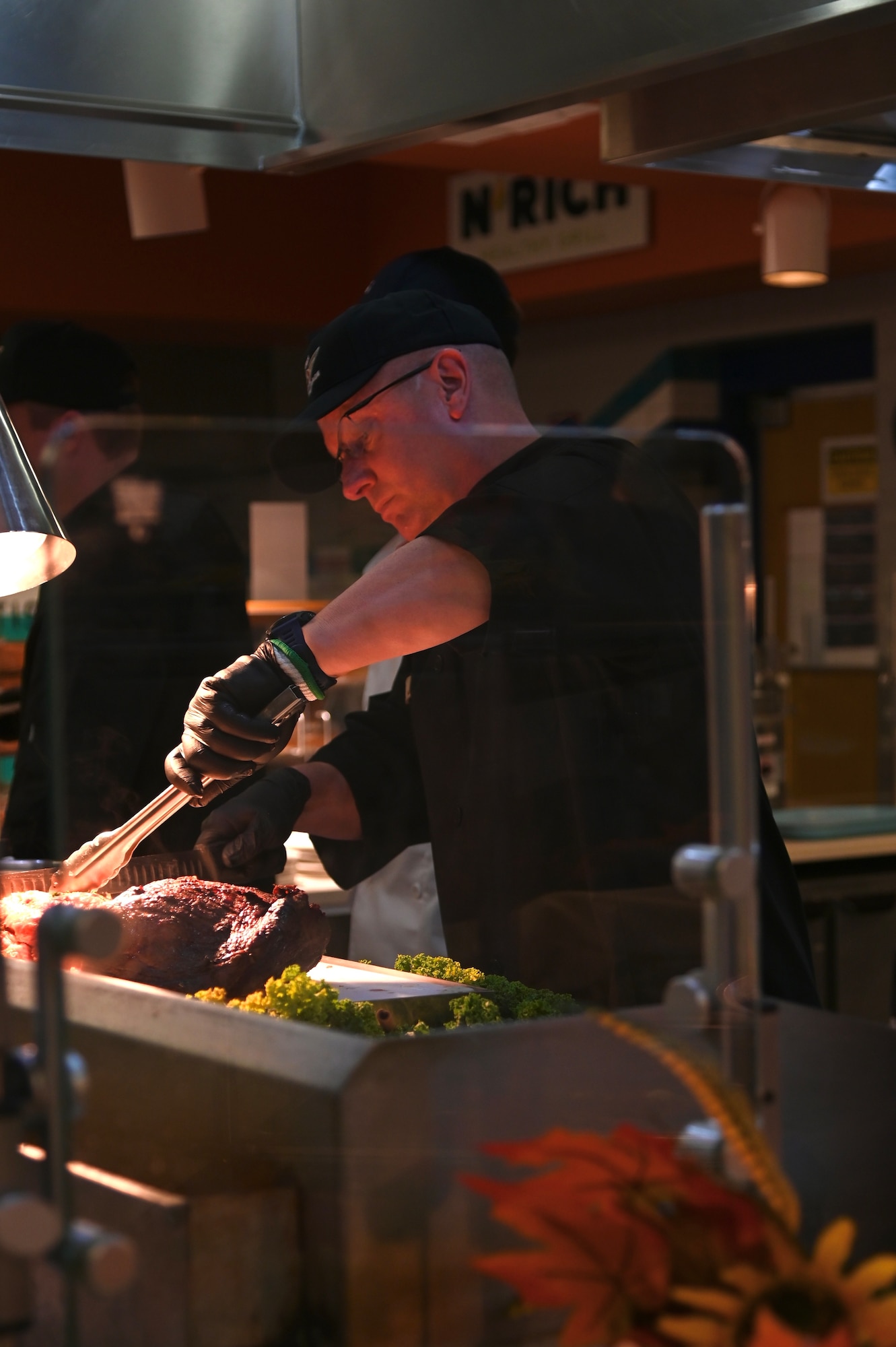 thanksgiving meals served by base leadership, leadership is all in black chef outfits serving base members