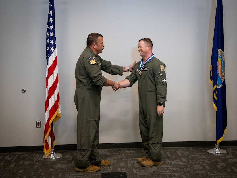 A guardian shakes hands with another guardian between two flags in a room.