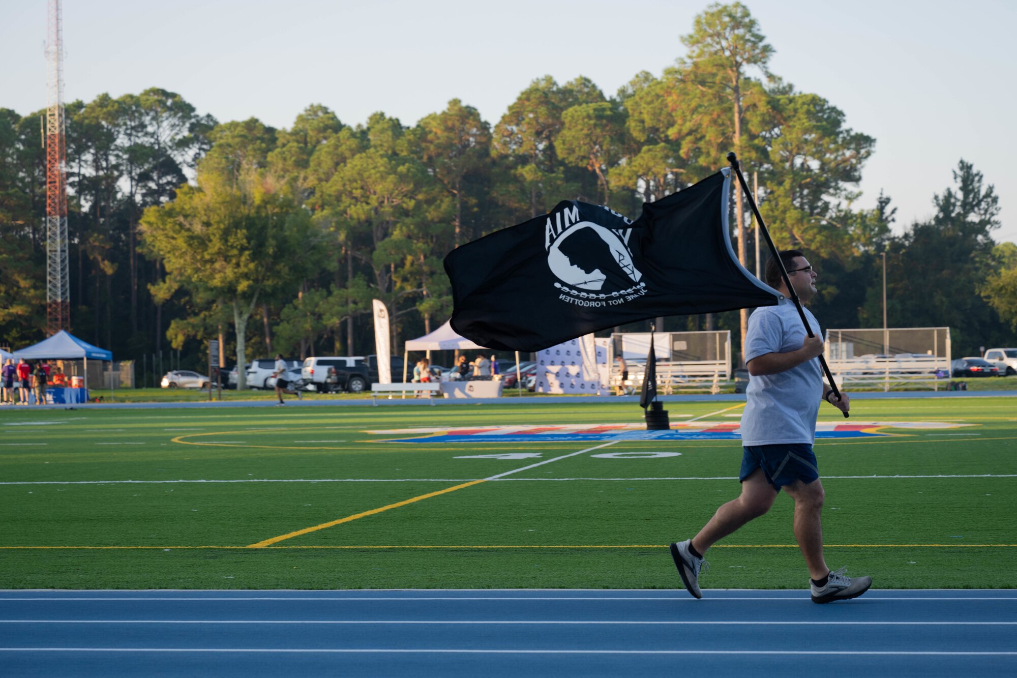 U.S. Air Force Master Sgt. Jean Cavalie Barrueta, a 1st Special Operations Force Support Squadron noncommissioned officer, runs with the POW/MIA flag at the Aderholt Fitness Center track at Hurlburt Field, Florida, Sept. 19, 2024.