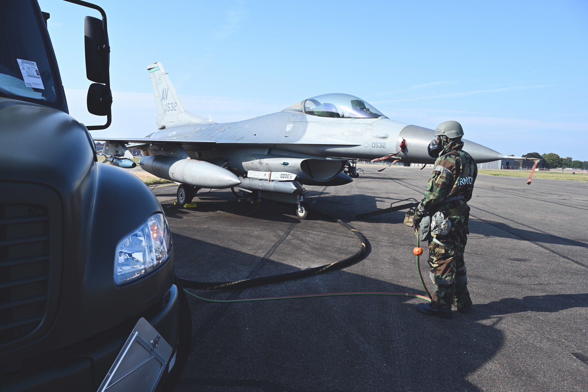 U.S. Air Force Senior Airman Jovon Green, 100th Logistics Readiness Squadron Petroleum, Oils and Lubricants flight fuels distribution technician, monitors fuel flow from an R-11 Refueler truck to an F-16 Fighting Falcon from Aviano Air Base, Italy, while wearing mission-oriented protective posture gear at Royal Air Force Mildenhall, England, Sept. 19, 2024.