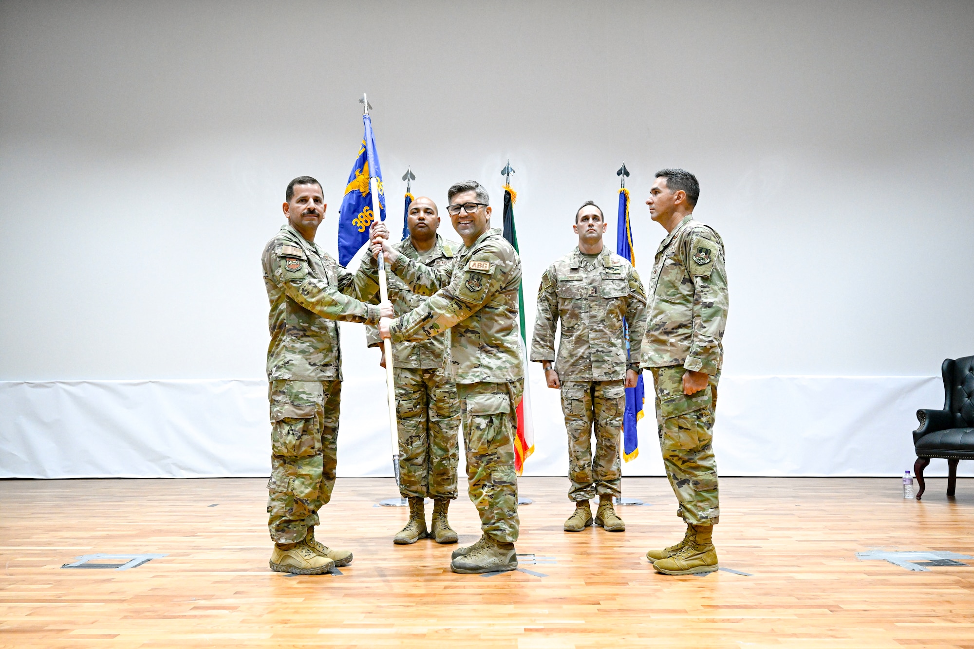 A man passes a guidon to another man during a ceremony.
