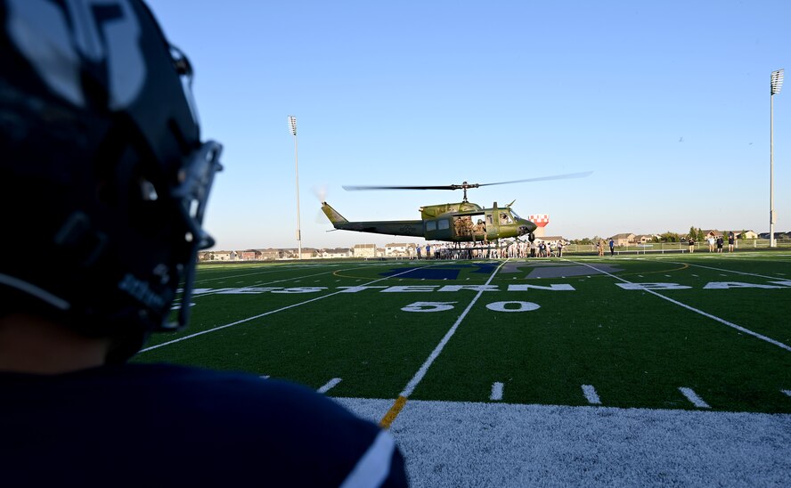 A UH-1 Iroquois assigned to the 54th Helicopter Squadron prepares to land at Sentinel Stadium after the National Anthem of a Minot North High School football game, Minot, North Dakota, Sept. 27, 2024. As a part of the pre-game ceremonies the 54th HS performed a fly-over and delivered 91st Missile Wing leadership to give the game ball to officials at the start of the game. (U.S. Air Force photo by Tech. Sgt. Rusty Frank)