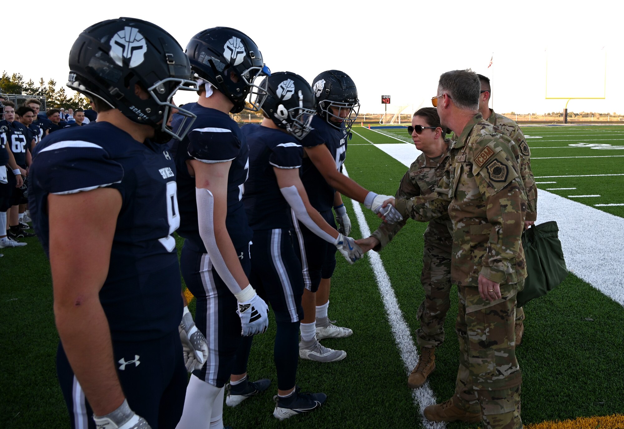 Members of the 91st Missile Wing greet players of the Minot North High School football team prior to the game at Minot, North Dakota, Sept. 27, 2024. The 91st MW delivered the game ball to kick-off the first homecoming game of Minot North High School. (U.S. Air Force photo by Tech. Sgt. Rusty Frank)