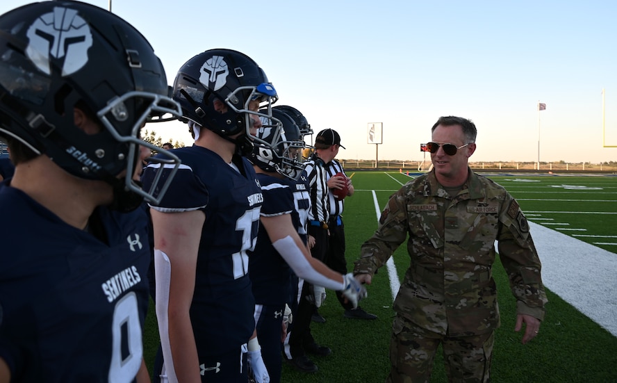 U.S. Air Force Col. James Schlabach, 91st Missile Wing commander, greets players of the Minot North High School football team prior to the game at Minot, North Dakota, Sept. 27, 2024. The 91st MW delivered the game ball to kick-off the first homecoming game of Minot North High School. (U.S. Air Force photo by Tech. Sgt. Rusty Frank)