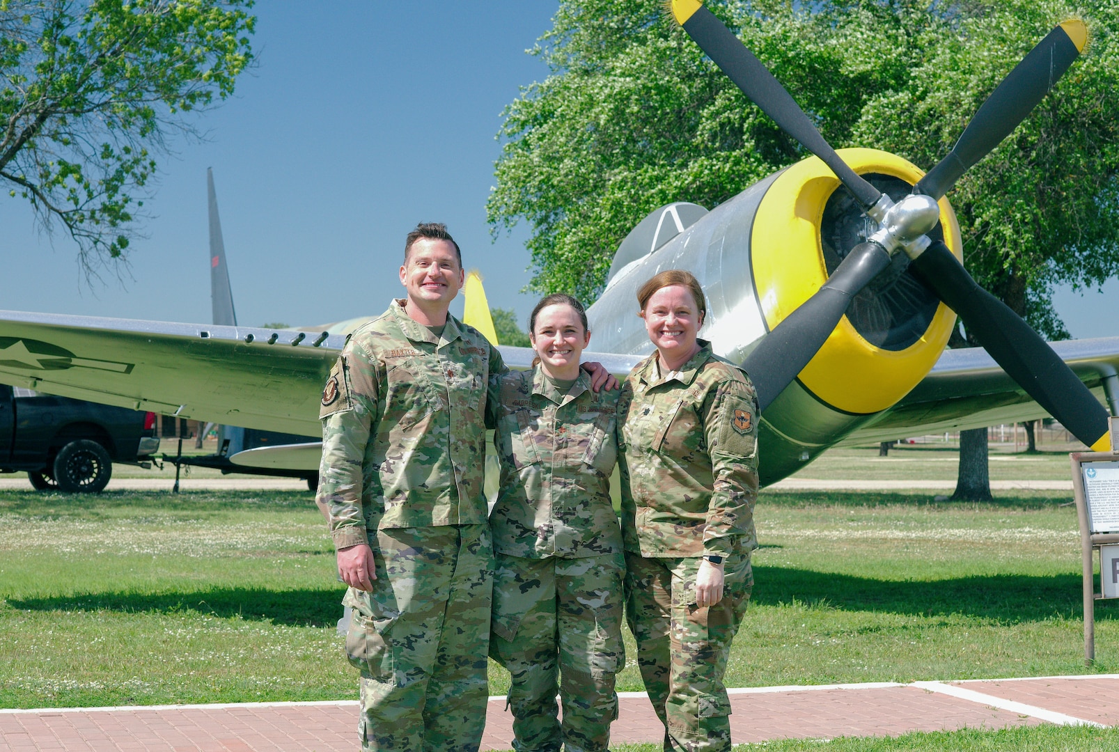 U.S. Air Force Lt. Col. Joseph Baxter, allergist and immunologist with the 56th Healthcare Operations Squadron, Maj. Lauren Gabreski, allergist and immunologist with the 48th HCOS, and Lt. Col. Tasha Hellu, allergist and immunologist with the 10th HCOS, pose for a graduation photo by a Republic P-47 Thunderbolt at the Lackland Parade Field, Joint Base San Antonio-Lackland, Texas, in June 2024. Gabreski’s grandfather, retired Air Force Col. Francis “Gabby” Gabreski, flew the Republic P-47 Thunderbolt during World War II and the Korean War, becoming one of only seven U.S. combat pilots to achieve ace status in two wars. (U.S. Air Force courtesy photo)