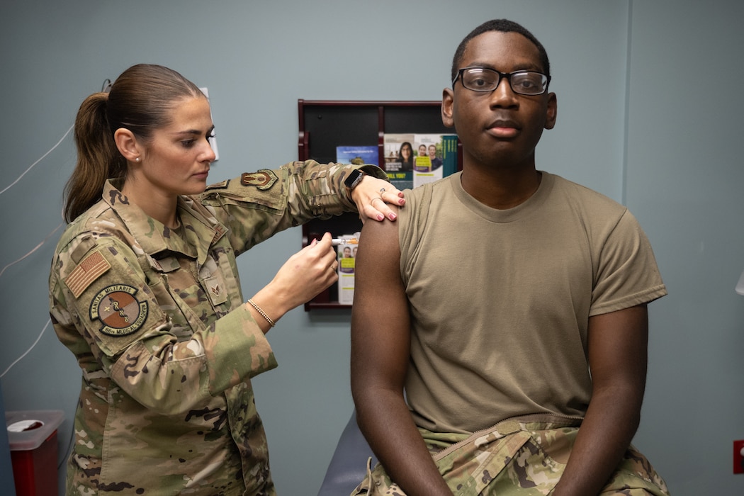 A flu shot is injected into a person's arm.