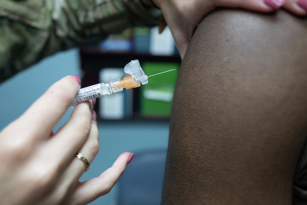 A flu shot is injected into a person's arm.