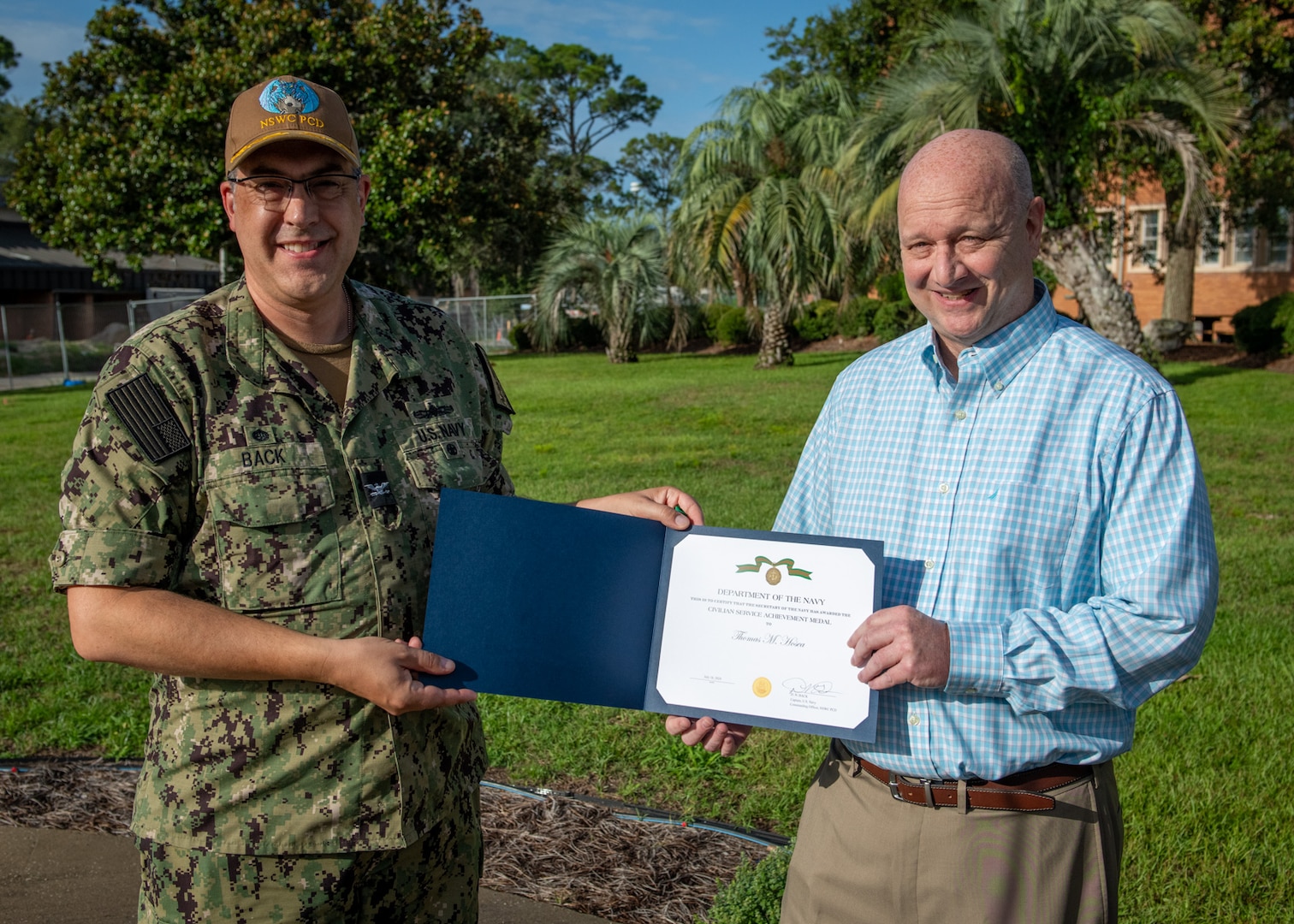 (left) Capt. David Back, Naval Surface Warfare Center Panama City Division commanding officer, presents Project Management Competency Lead Tommy Hosea with the Navy Civilian Service Achievement Medal for leading wartime readiness efforts during the Naval Sea Systems Command 2024 exercise, July 26. The 21-day, large-scale, multi-organizational event focused on wartime readiness to support the fleet. (U.S. Navy photo by Anthony Powers)