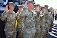 U.S. service members from multiple branches of the Armed Forces raise their right hands during a reenlistment ceremony held at the Kansas Speedway on September 29, 2024, before the start of the Hollywood 400 NASCAR Cup Series race.