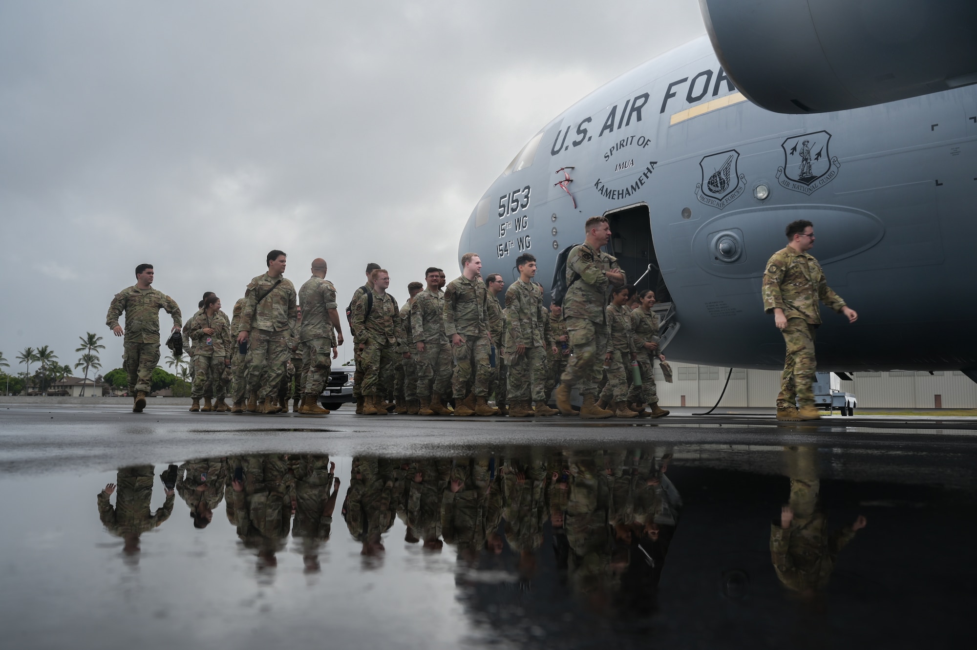 Airmen board a military cargo aircraft.