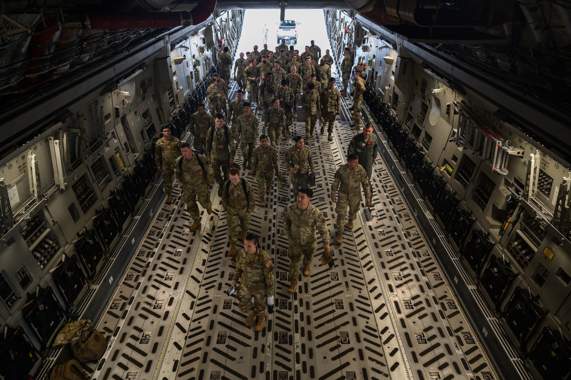 Airmen board a military cargo aircraft.
