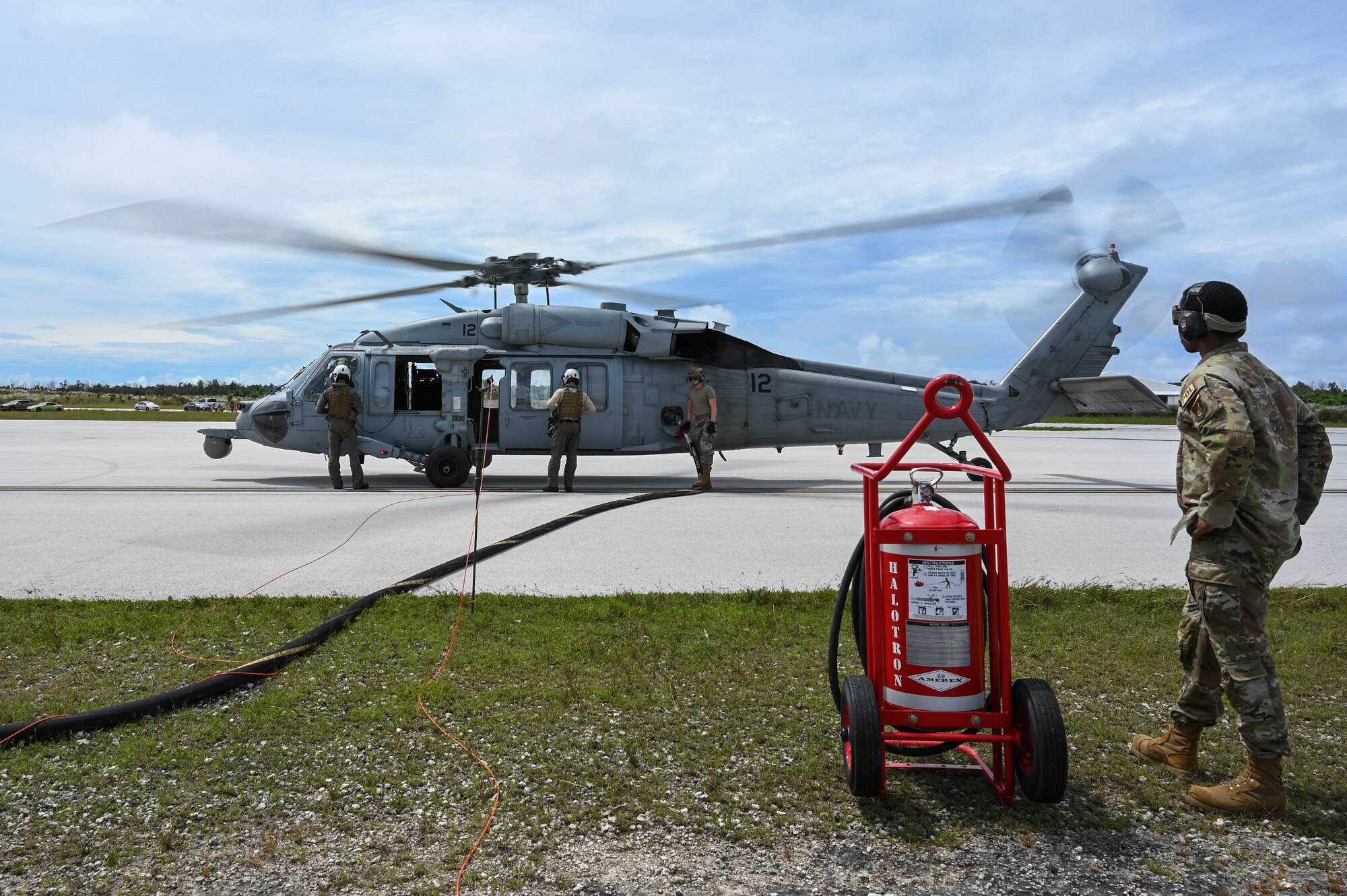Tech. Sgt. Clarence Graves, 36th Logistics Readiness Squadron fuels flight superintendent, supervises the refueling of an U.S. Navy HSC-25 helicopter at the Pacific Regional Training Center – Andersen Air Force Base, Guam on Sept. 24, 2024. The 36th LRS worked with the 36th Contingency Response Squadron to get their newest Airmen familiar with the hot-pit refueling process. (U.S. Air Force photo by Airman 1st Class Natasha Ninete)