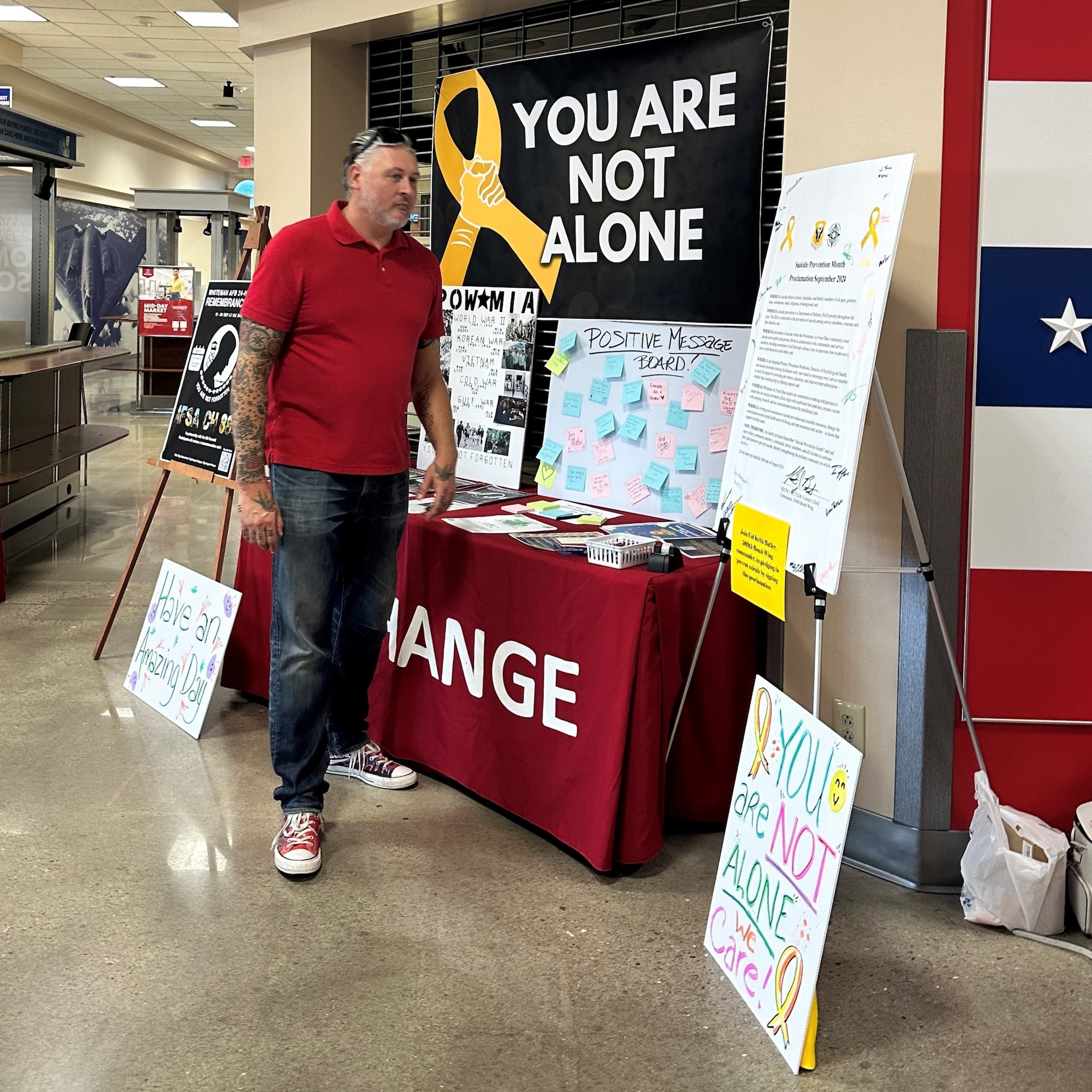 A man stands at a display table inside a base exchange