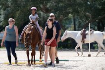 A young child rides upon a horse alongside Sand and Spur Club members.