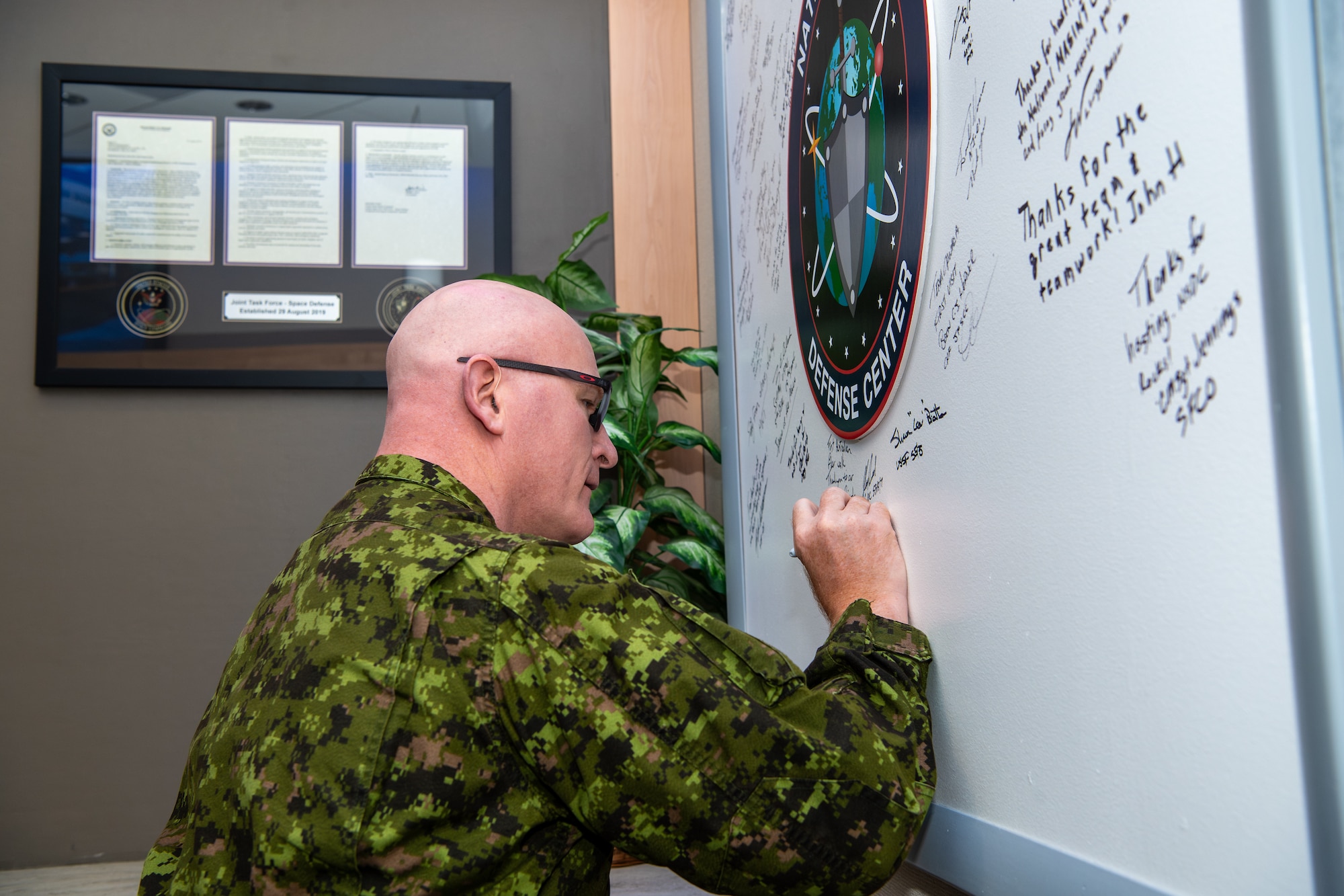 Man in Canadian military signs board