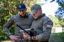 Polish Land Forces Cpl. Nikodem Stelmaszek, left, and Warrant Officer Blazej Basinski, 16th Airfield Renovation Battalion explosive ordnance disposal (EOD) technicians, examine an X-ray of a simulation booby trap.