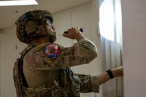 U.S. Air Force Staff Sgt. Sho Kasahara, 35th Civil Engineer Squadron explosive ordnance disposal (EOD) technician, checks a door for booby-traps.