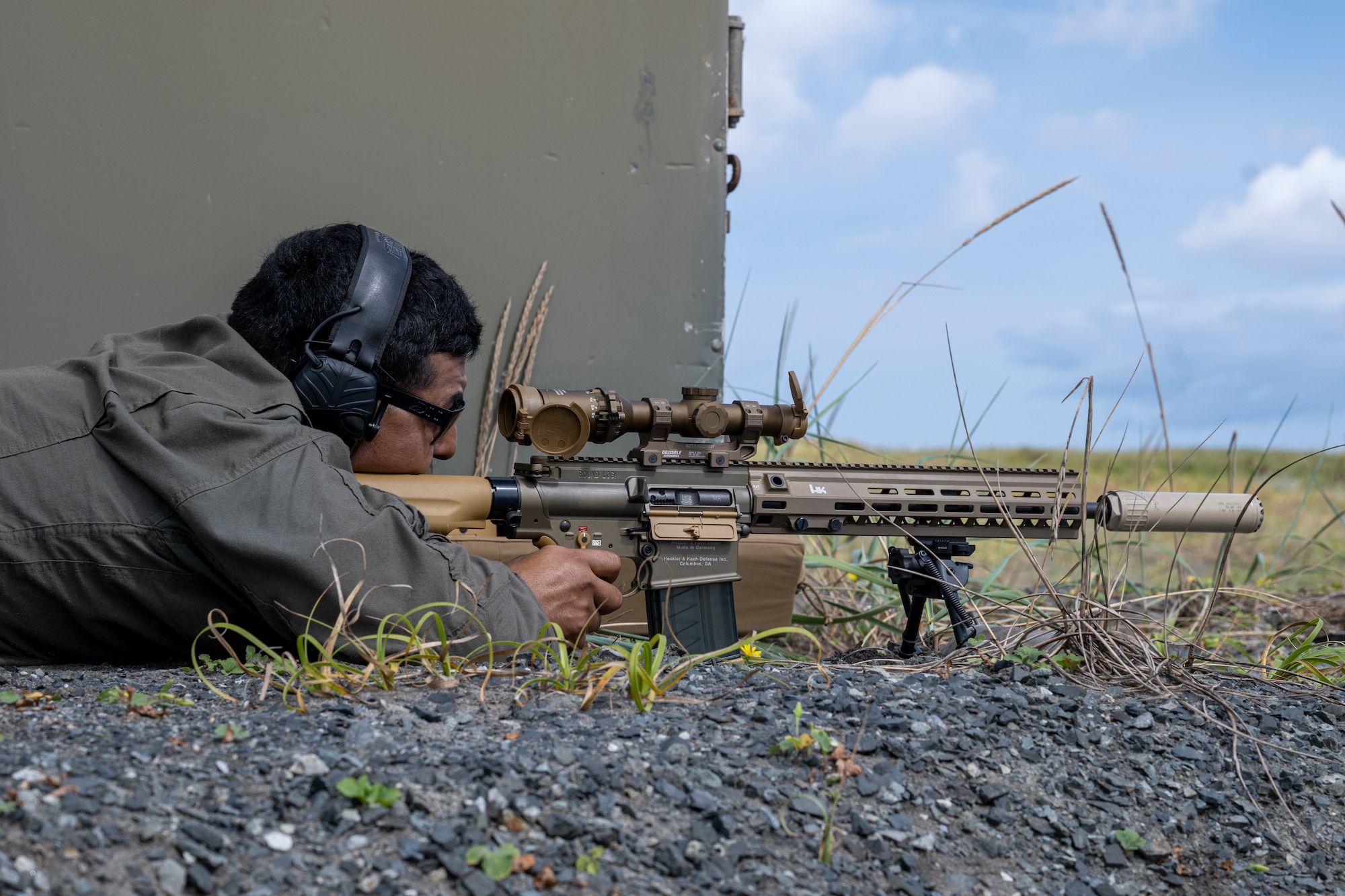 U.S. Marine Corps Staff Sgt. Cesar Martinez, explosive ordnance disposal response element leader with Headquarters and Headquarters Squadron, Marine Corps Air Station Iwakuni, fires an M110 Semi-Automatic Sniper System at simulated munitions.