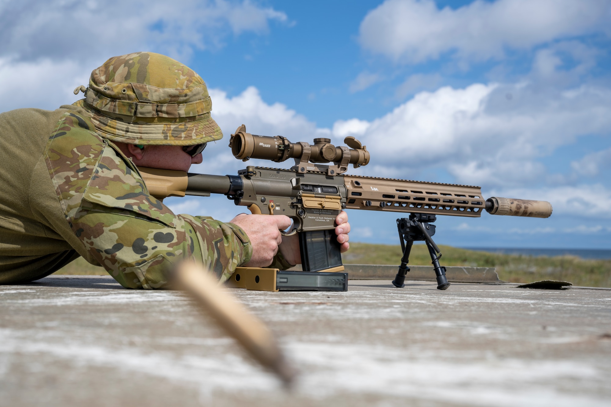 Royal Australian Air Force Flight Sgt. Tristan Crump, explosive ordnance disposal (EOD) observer, fires an M110 Semi-Automatic Sniper System.