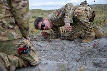 U.S. Air Force Airman 1st Class Justin Chamberlain, 35th Civil Engineer Squadron explosive ordnance disposal logistics team member, inspects a crater during the blast investigation portion of an Operation Sentinel Samurai exercise at Draughon Range.