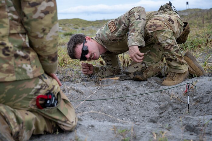 U.S. Air Force Airman 1st Class Justin Chamberlain, 35th Civil Engineer Squadron explosive ordnance disposal logistics team member, inspects a crater during the blast investigation portion of an Operation Sentinel Samurai exercise at Draughon Range.