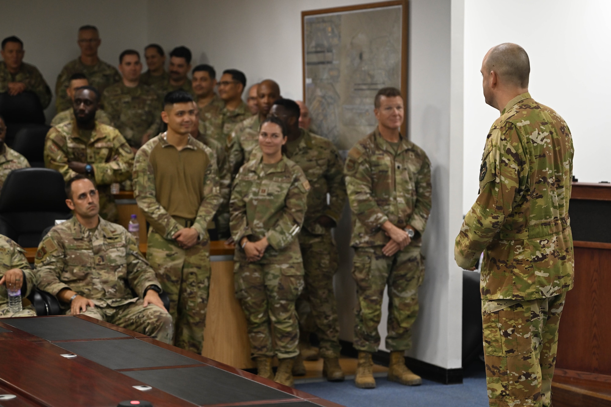 A man wearing his military uniform addresses an audience of Airmen during a ceremony.