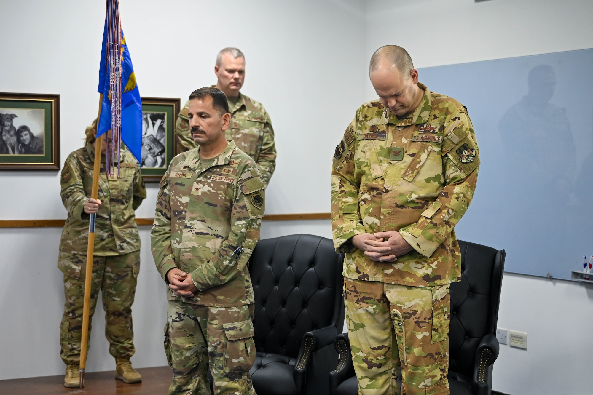 Two men bow their heads during a ceremony.