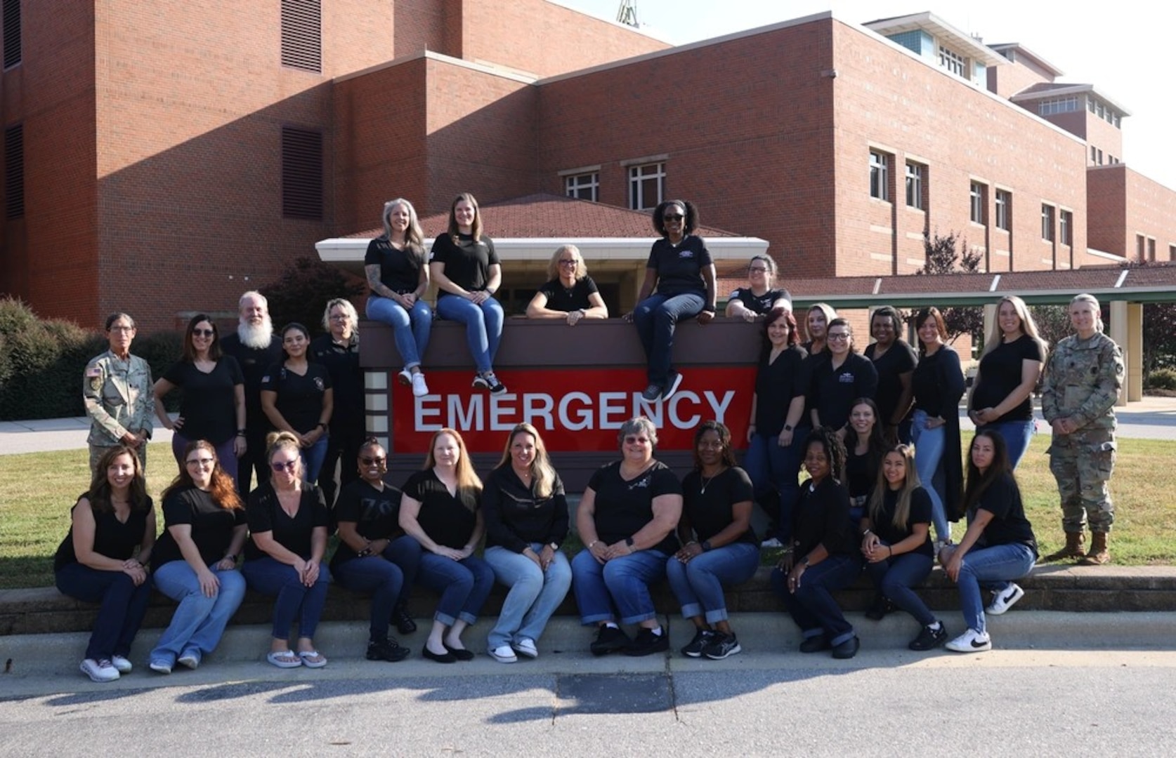 Womack Army Medical Center (WAMC) Forensic Health Care Examiners pose for a picture around the emergency sign in front of WAMC Emergency room entrance, August 29, 2024.