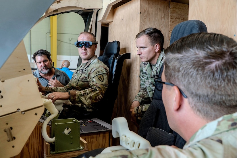 Three soldiers and a civilian participate in a demonstration of Army equipment.