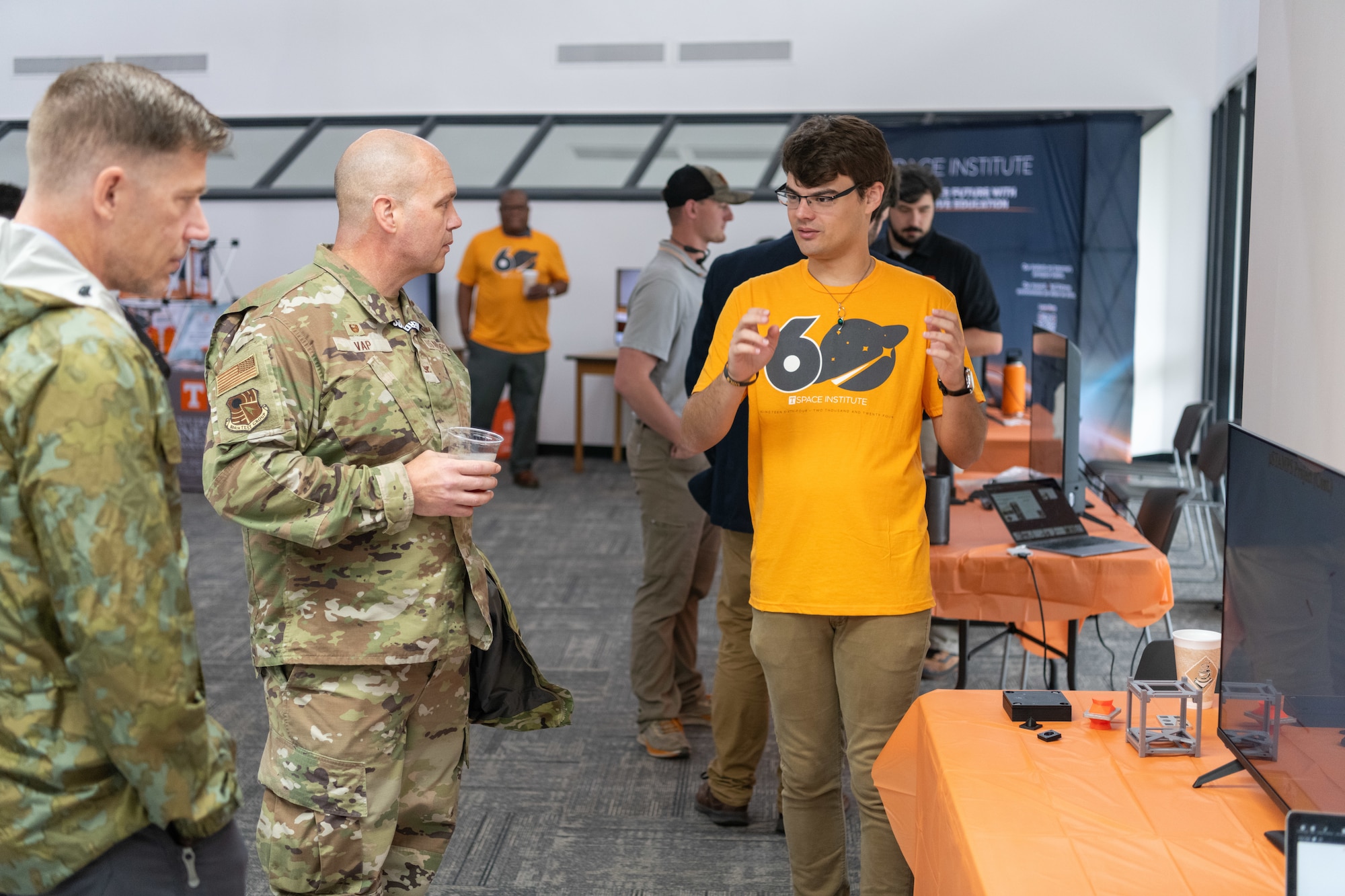 Arnold Engineering Development Complex 804th Test Group Commander Col. Jason Vap speaks with University of Tennessee doctoral student Christian Sharpe Sept. 27, 2024, during the University of Tennessee Space Institute 60th anniversary celebration at the institute, which is located near Arnold Air Force Base, Tenn., headquarters of AEDC. The first UTSI classes began on Sept. 24, 1964, in offices provided by the Air Force at AEDC as the institute was under construction at the time. More than 500 AEDC employees have earned graduate degrees at UTSI since its inception. (U.S. Air Force photo by Keith Thornburgh)