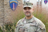 A male Soldier in uniform poses for a phtograph.