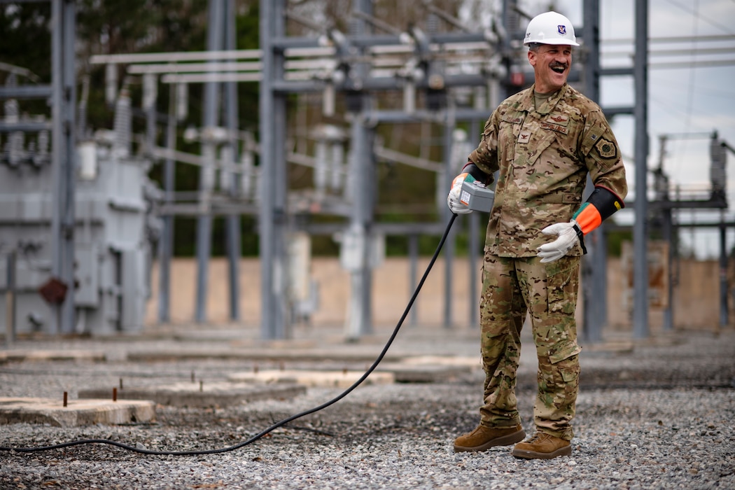 Person holding a control switch to an electrical circuit at a substation