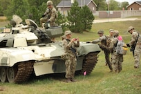 Soldiers gather around a T-72 main battle tank.