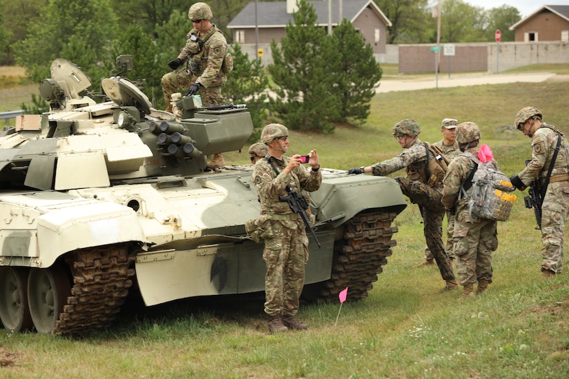 Soldiers gather around a T-72 main battle tank.