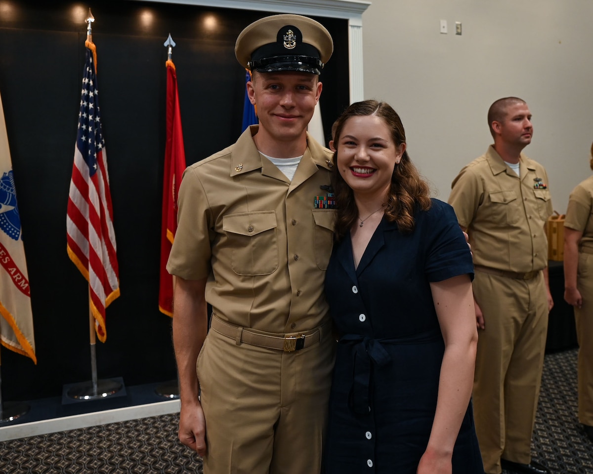 U.S. Navy Cryptologic Technician Collection Chief Petty Officer Josef Luedloff, Information Warfare Training Command Monterey Detachment Goodfellow N312 Division leading petty officer, takes a photo with his wife Jenna Joy Luedloff at the Fiscal Year 2025 CPO Pinning Ceremony at the Powell Event Center, Goodfellow Air Force Base, Texas, Sept. 27, 2024. After being pinned with their anchors, each chief received a combination cover, signifying a new position of leadership and responsibility. (U.S. Air Force photo by Airman 1st Class Evelyn J. D’Errico)