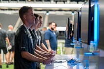 A group of Airmen play video games in the football stadium.