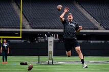 An Airman jumps to catch a football.