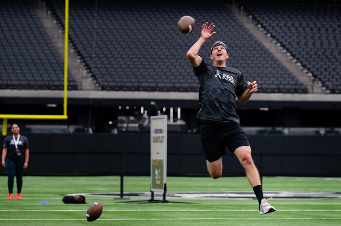 An Airman jumps to catch a football.
