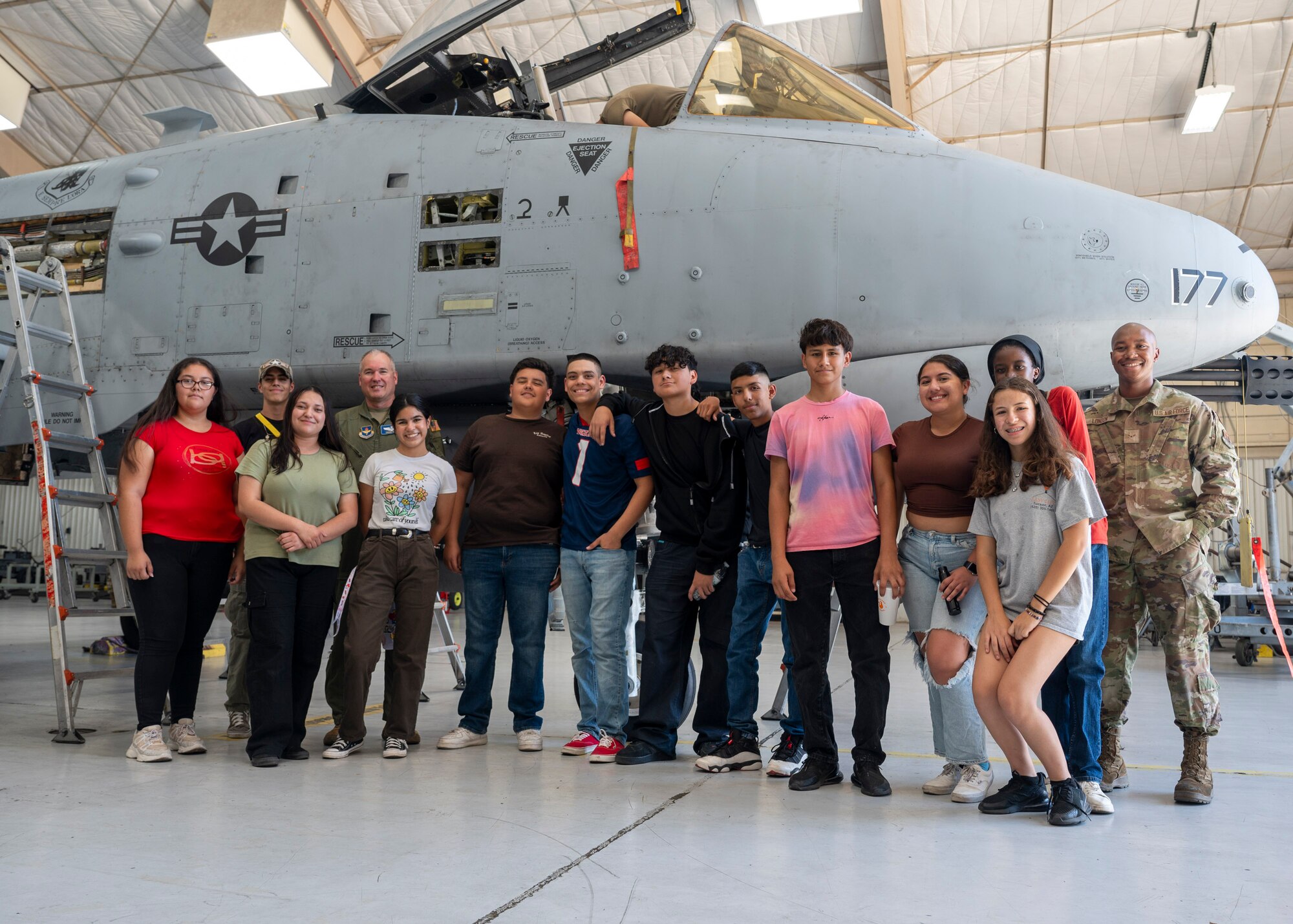 U.S. Airmen pose for a group photo with Air Force Junior Reserve Officer Training Corps students in front of an A-10C Thunderbolt II aircraft,