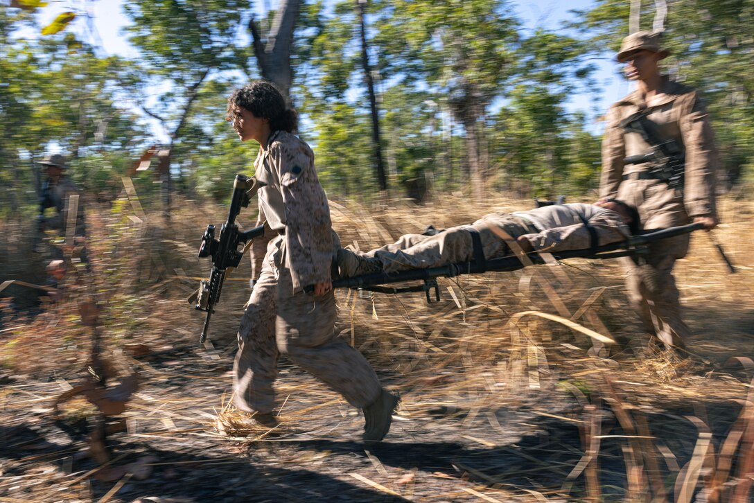 U.S. Navy Petty Officer 2nd Class Rawan Hassanein, left, a hospital corpsman with Echo Company, 2nd Battalion, 5th Marine Regiment (Reinforced), Marine Rotational Force – Darwin 24.3, evacuate a simulated casualty during Exercise Predators Walk at Mount Bundey Training Area, NT, Australia, May 21, 2024. During Predators Walk, Marines were able to conduct a live-fire squad range further developing the skills and confidence needed to succeed at the small unit level. Hassanein is a native of Colorado. (U.S. Marine Corps photo by Cpl. Juan Torres)