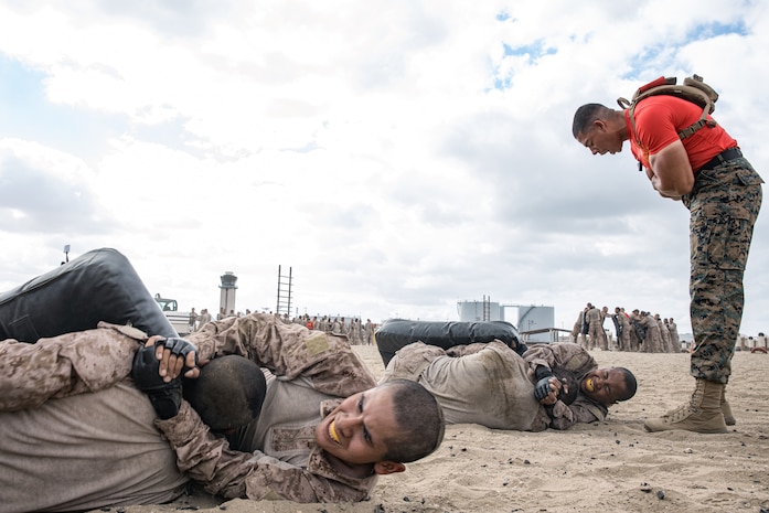 U.S. Marine Corps Sgt. Marvin Fuentes, a drill instructor with Alpha Company, 1st Recruit Training Battalion, gives instructions to recruits on how to properly execute grounded knee strikes during the combat conditioning course at Marine Corps Recruit Depot San Diego, California, Sept. 17, 2024. The CCX is designed to increase recruits’ stamina and ability to perform Marine Corps Martial Arts Program techniques. (U.S. Marine Corps photo by Cpl. Sarah M. Grawcock)