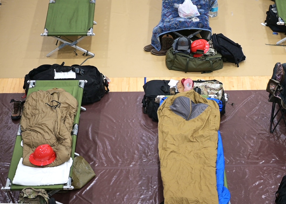 Rows of cots in a gymnasium