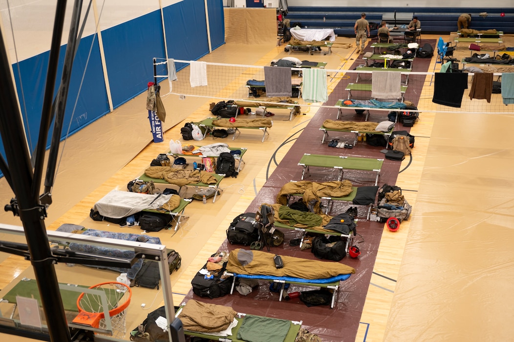 Rows of cots in a gymnasium