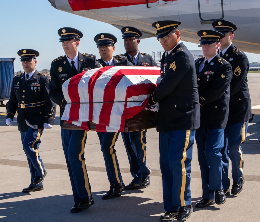 A Military and Funeral Honors team carries the flag-draped coffin of Illinois Army National Guard Pfc. Harry Jerele to the awaiting hearse at O’Hare International Airport in Chicago Oct. 1.