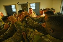 Leadership assigned to the 891st Missile Security Forces Squadron (MSFS) huddle up in preparation for Operation Cerberus at Camp Ripley, Minnesota, Sept. 22, 2024. Operation Cerberus was a readiness exercise designed to simulate a deployed environment and give an opportunity for Airmen of 891 MSFS to test their expeditionary skills.